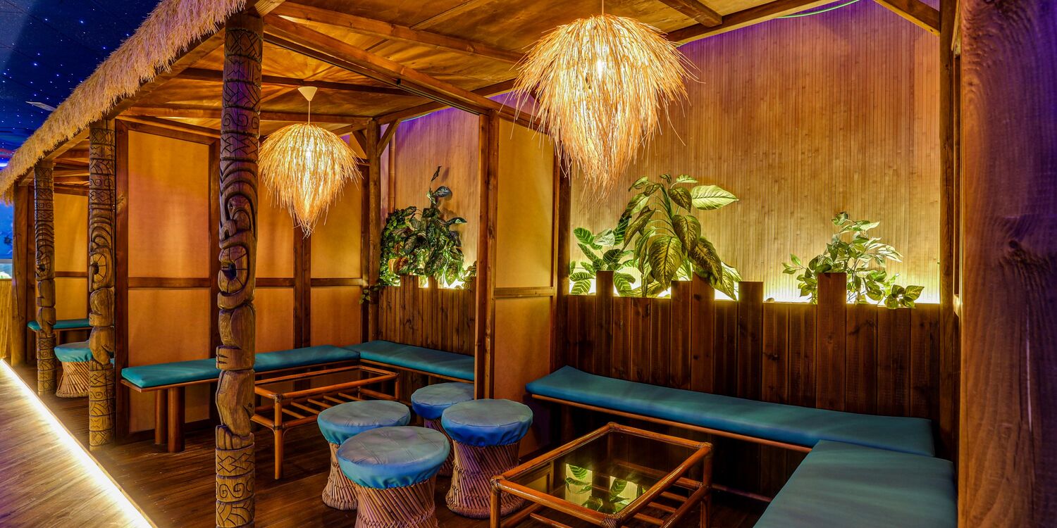 Cabañas cubiertas de la terraza de Kahiki Mataró con vegetación y techo estrellado